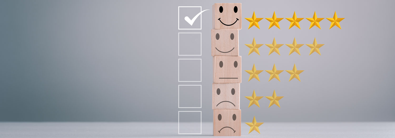 Stack of wooden blocks with smileys and a star scale, highlighting a top CX and satisfaction rating